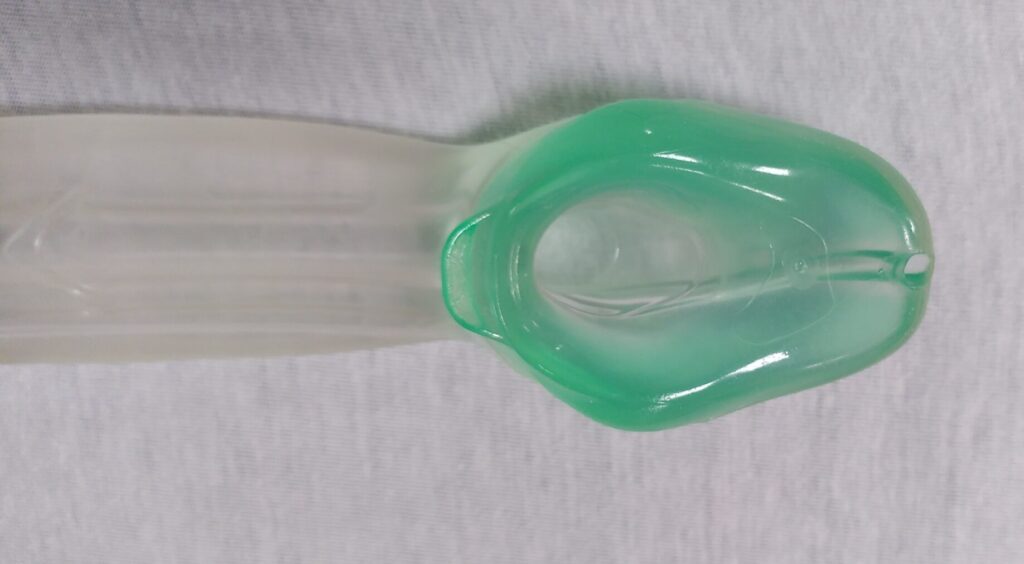 Extrem proximal de la mascareta I-gel on s'aprecia l'obertura que ha de quedar situada davant la laringe. Al voltant d'aquesta obertura, i en una forma romboidal arrodonida, s'hi troba el material tou viscós que fa el segell de la laringe taponant l'esòfag. A la part més proximal del dispositiu s'hi veu l'orifici per a facilitar el pas del tub d'aspiració gàstric. A l'altre extrem del segell hi veiem el suport per l'epiglotis, una mena de pestanya per evitar que aquesta epiglotis quedi doblegada de forma que obstrueixi la via aèria.