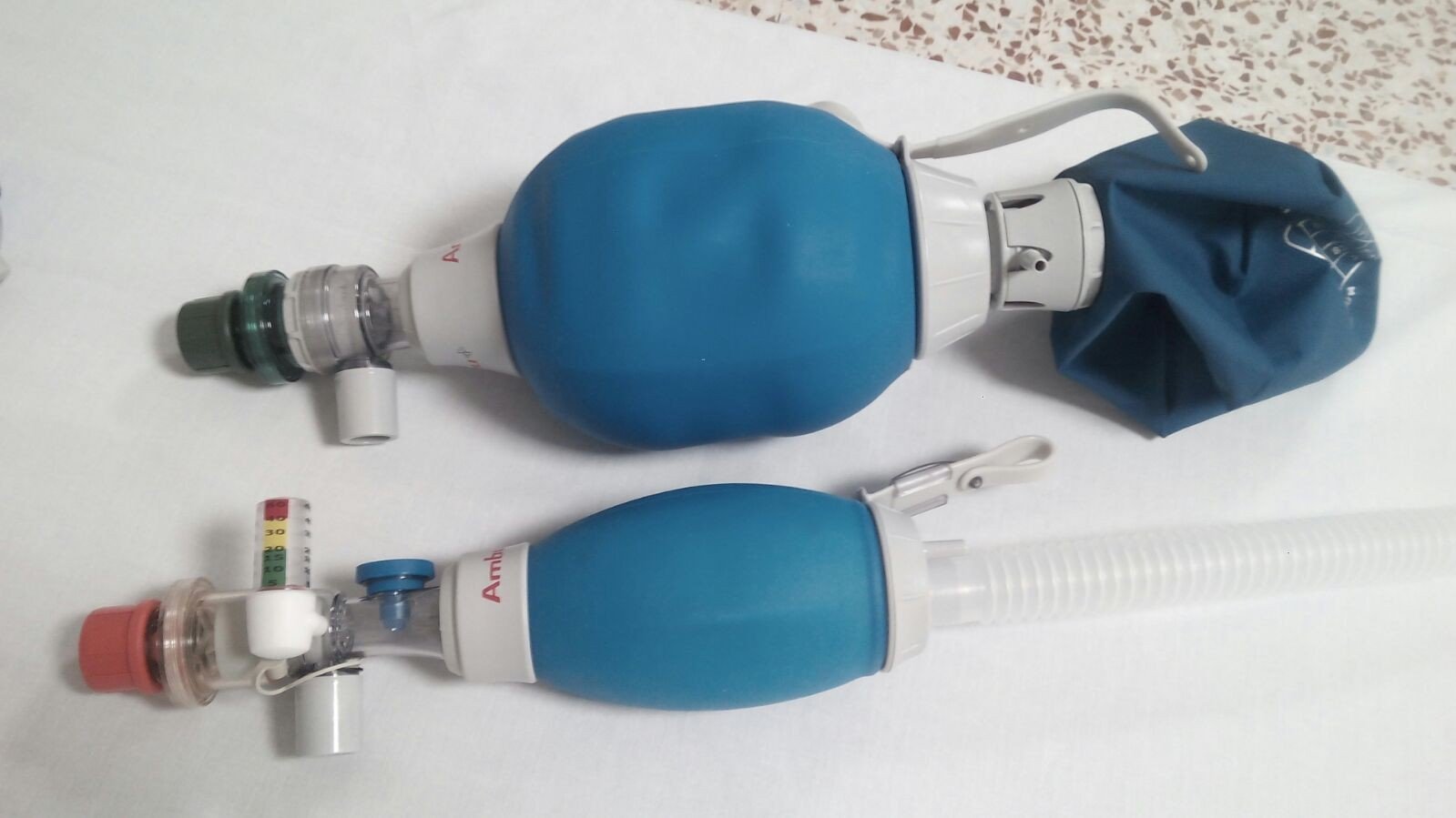 Respirador manual d'adult (o ambu) amb bossa reservori d'O2 a la part superior. Respirador manual neonatal a la part inferior, amb mesurador de pressió i coarrugat per a reservori d'oxigen. Ambdós dispositius amb vàlvula de PEEP al port espiratori