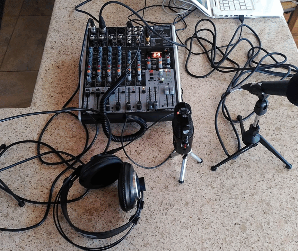 Micròfons, taula de mescles i auriculars damunt una taula