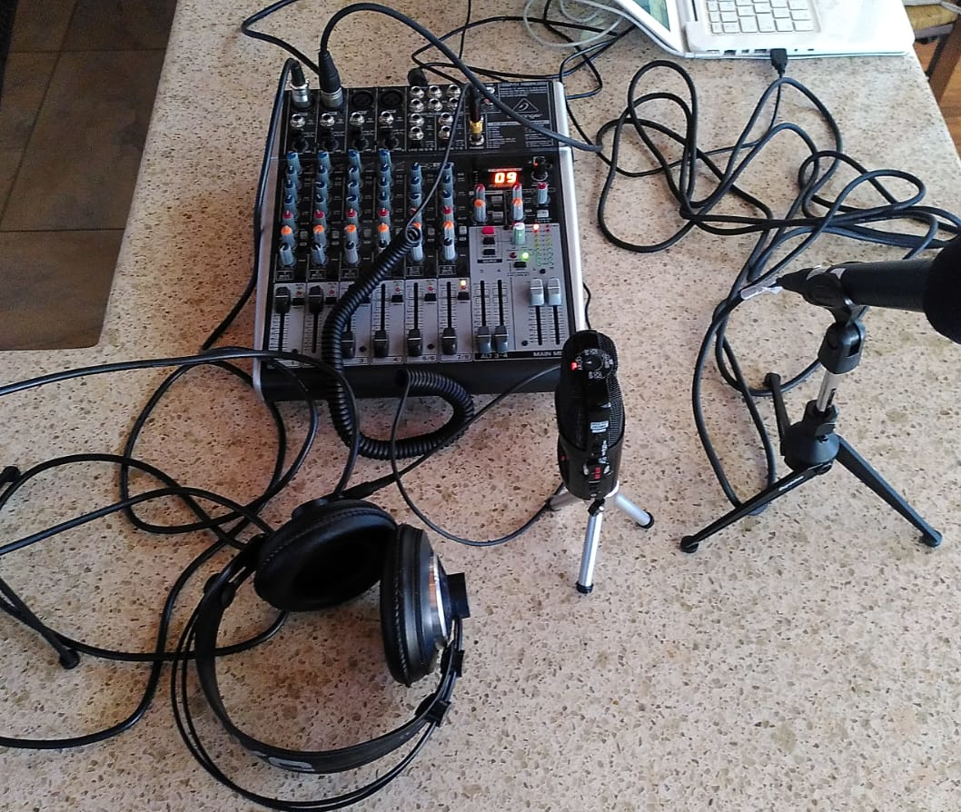 Micròfons, taula de mescles i auriculars damunt una taula