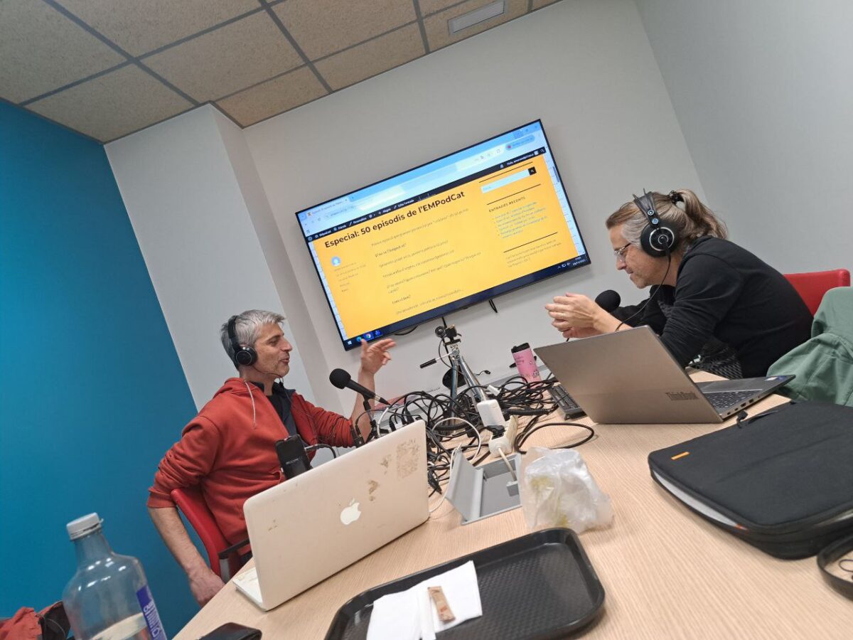 Dos homes gravant un pòdcast amb tot d'aparells damunt una taula